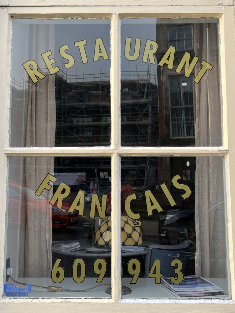 Window of Bouchon Bistro a Hexham restaurant with french writing on