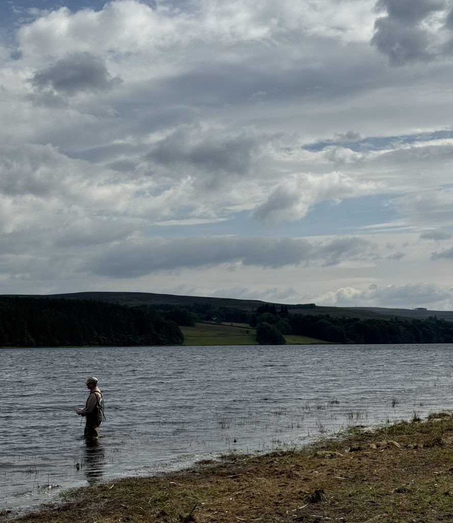 Fisherman at Derwent Reservoir with moody sky